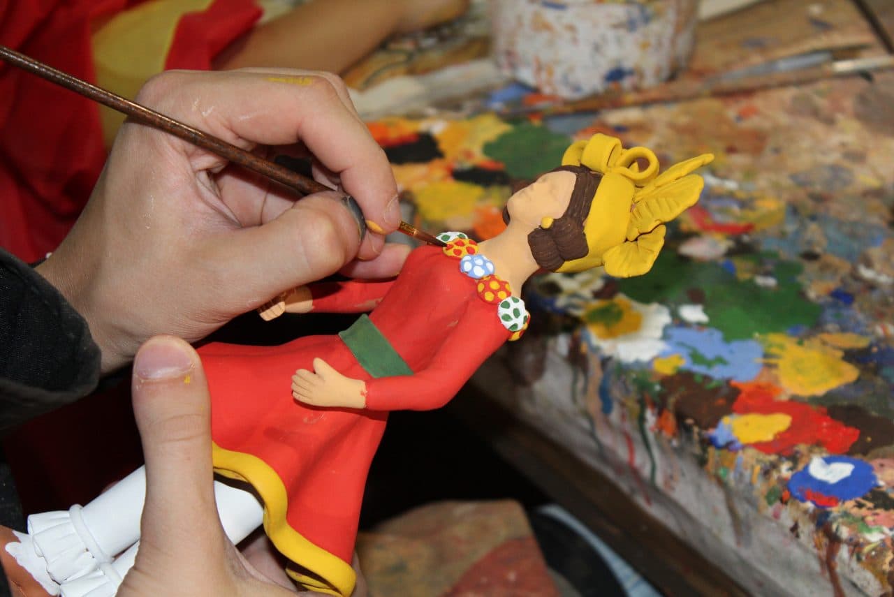 Artesã a criar uma figura na Feira Nacional de Artesanato.